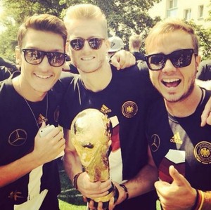 Ozil, André Schürrle e Mário Götze com a taça do Campeonato Mundial de 2014  https://www.football-king.com/articles/germany-world-cup-celebrations-berlin-15-07-2014/